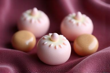 Pastel-colored sugar drops shaped like miniature pocket watches on a velvet display